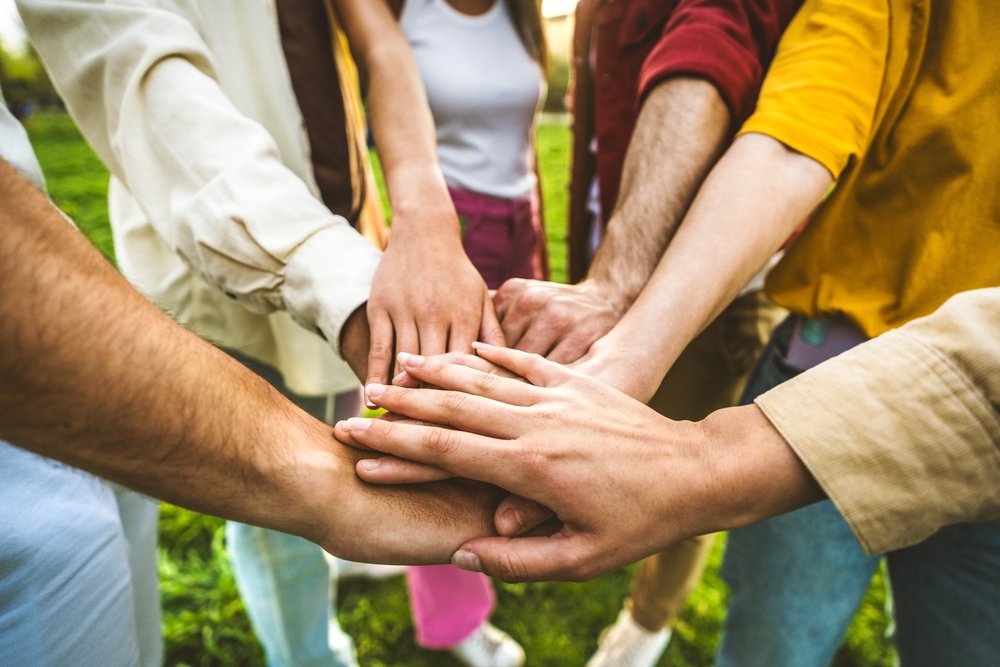 Grupo de personas apilando las manos juntas